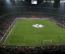 Ein Fußballstadion mit einer großen Anzeigetafel und einem Logo in der Mitte des Spielfeldes.