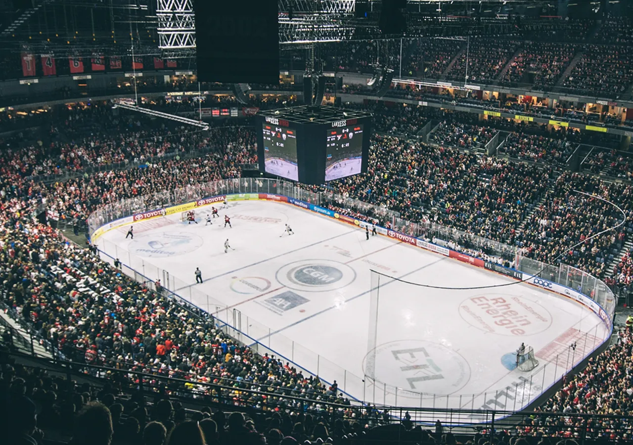 Eine weite Sicht auf ein Eisstadion während eines Eishockeyspiels mit einer großen Menschenmenge.
