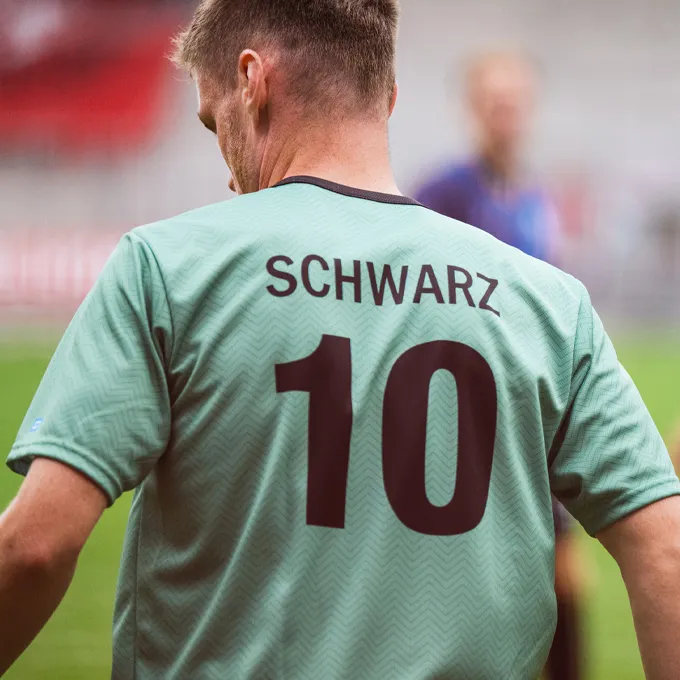 Ein Spieler trägt ein mintgrünes Fußballtrikot mit der Nummer 10 und dem Namen 'SCHWARZ' auf dem Rücken.
