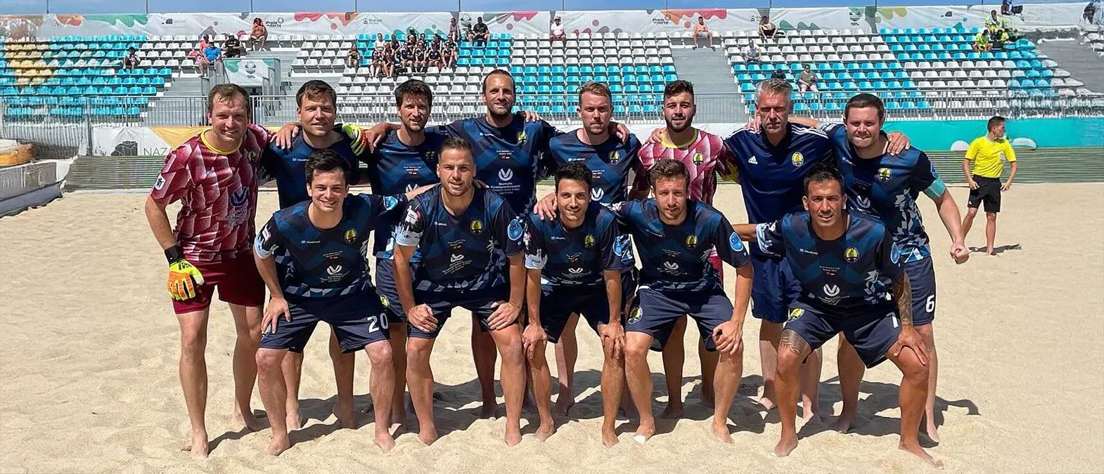 Ein Fußballteam posiert auf einem Sandplatz in personalisierten Sporttrikots, die von owayo hergestellt wurden.