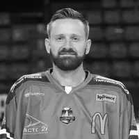 Ein Mann mit Bart trägt ein Eishockeytrikot mit verschiedenen Sponsorenlogos, darunter das Logo von owayo.