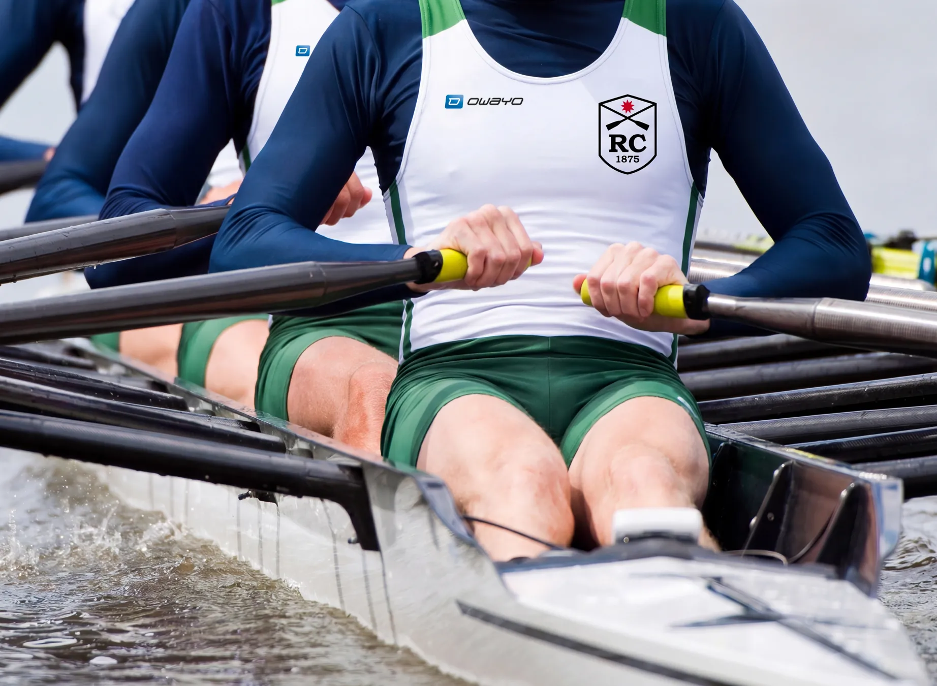 Eine Gruppe von Ruderern in maßgeschneiderter Sportbekleidung, die engagiert in einem Boot rudern.